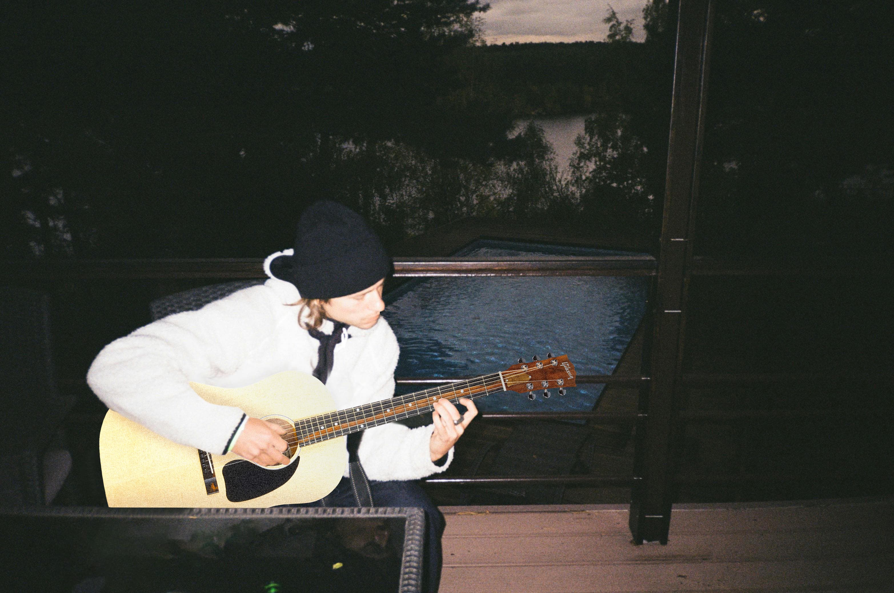 Person playing guitar at dusk